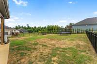 Large, fenced backyard with treeline views