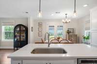 Quartz countertops and gas cooktop in this dream of a kitchen