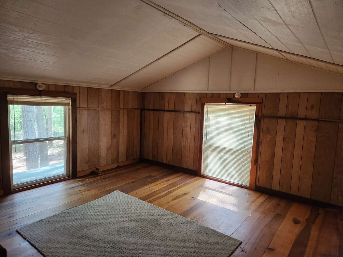 Second floor of cabin has three windows for bright light in the daytime. Pine floors.