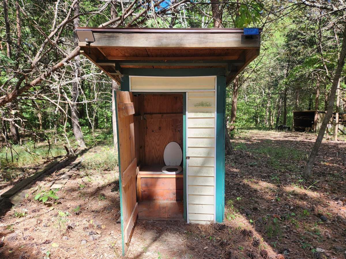 Nice one-seater outhouse with battery light inside and solar light outside.