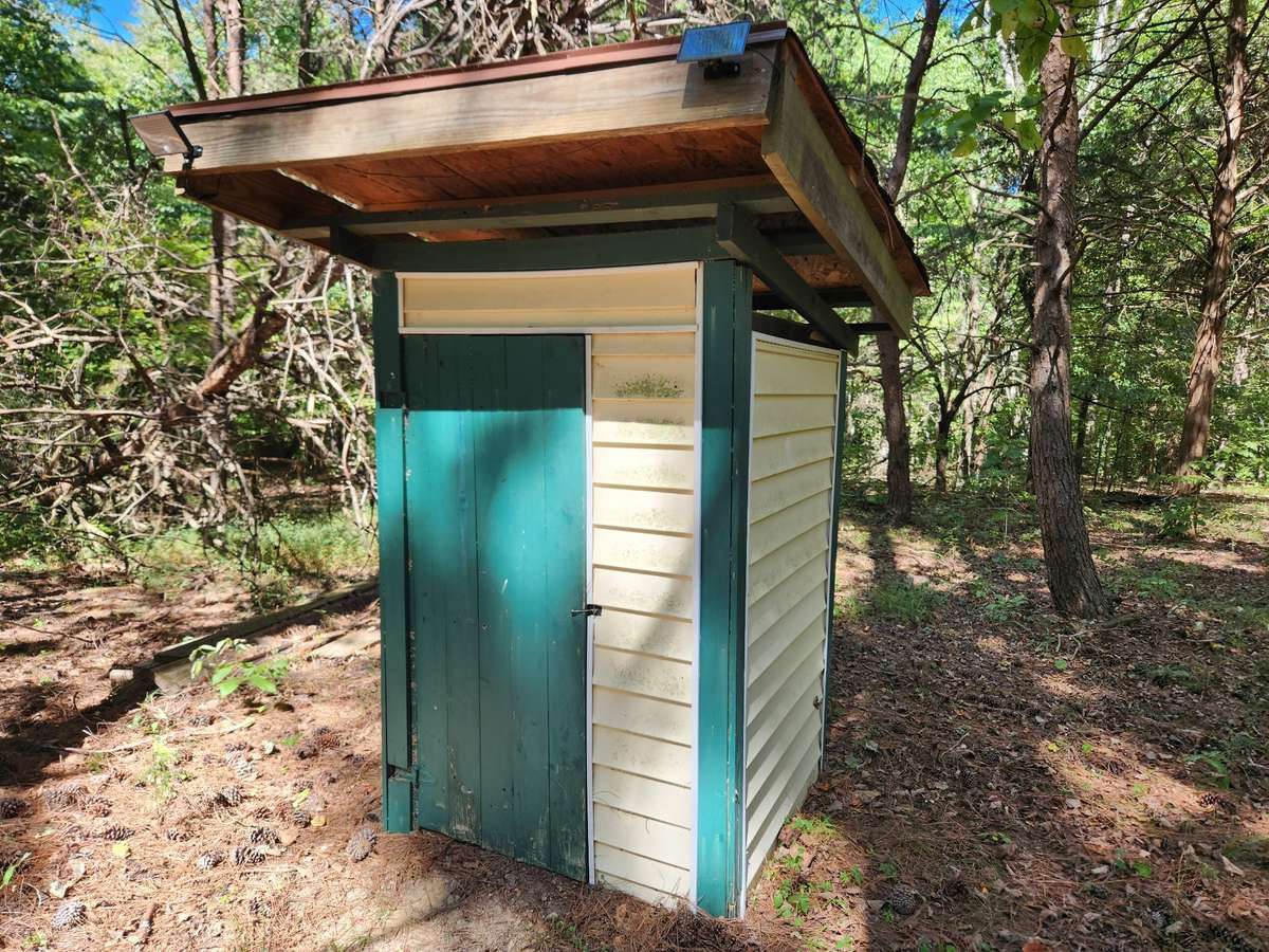 Nice one-seater outhouse wtih battery light inside and solar light outside.