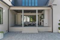 Spacious covered patio with fireplace overlooks the pool