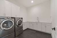 Full laundry on the main floor with sink and ample cabinetry.  Second laundry upstairs as well!