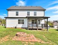 Back of home with firepit and covered deck.