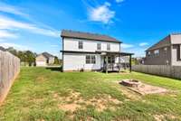 Back of home and backyard with firepit