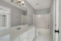 Crisp white bathroom featuring a single vanity, clean tile flooring, and a dual shower/tub combination—offering timeless style and everyday functionality. This is the second upstairs bathroom.