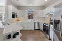 Bright and functional kitchen showcasing abundant classic white cabinetry with ample storage, sleek stainless steel appliances, and classic white subway tile backsplash for a clean, timeless look.