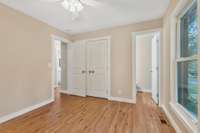 Primary bedroom shows off the new shaker trim, interior doors, laminate flooring and ceiling fan.  The half bath is just off this bedroom.