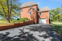 Garage in basement. Paved circle driveway