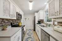 Kitchen with custom back splash and quartz counter tops.