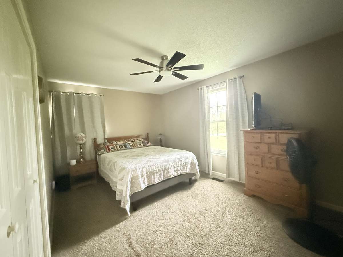 Primary Bedroom has ceiling fan with carpet bath