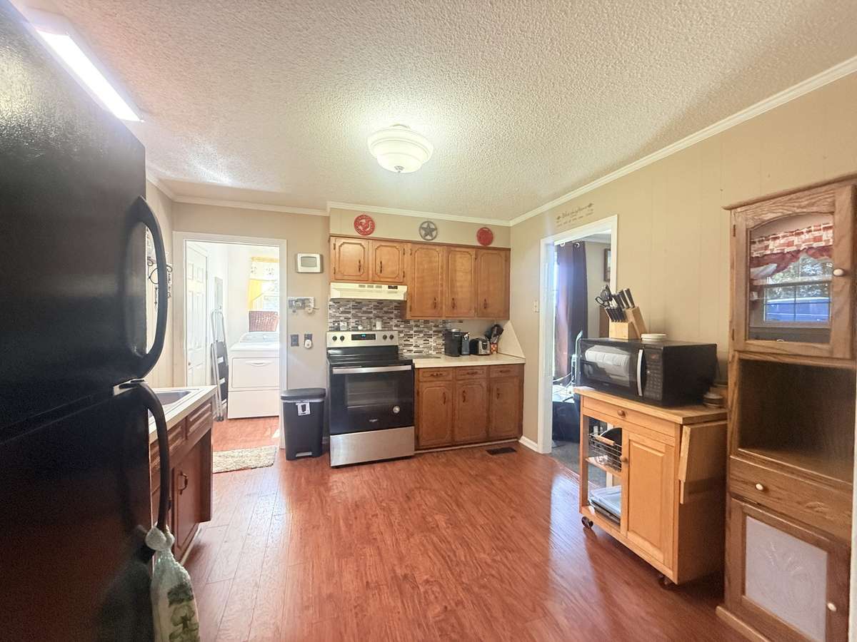 The kitchen has new hardwood flooring with a slide-in range and Refrigerator; the Kitchen flows into the Dining Room and Laundry Room