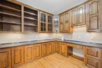 Office with french doors for privacy and built-in desk and cabinetry.