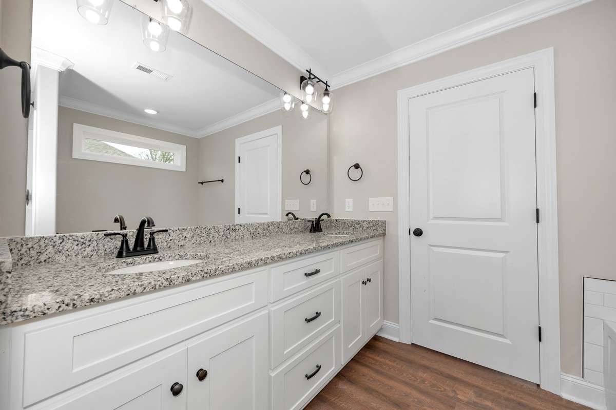 Primary Bath- LVP flooring, crown molding, separate tub & shower, double vanities