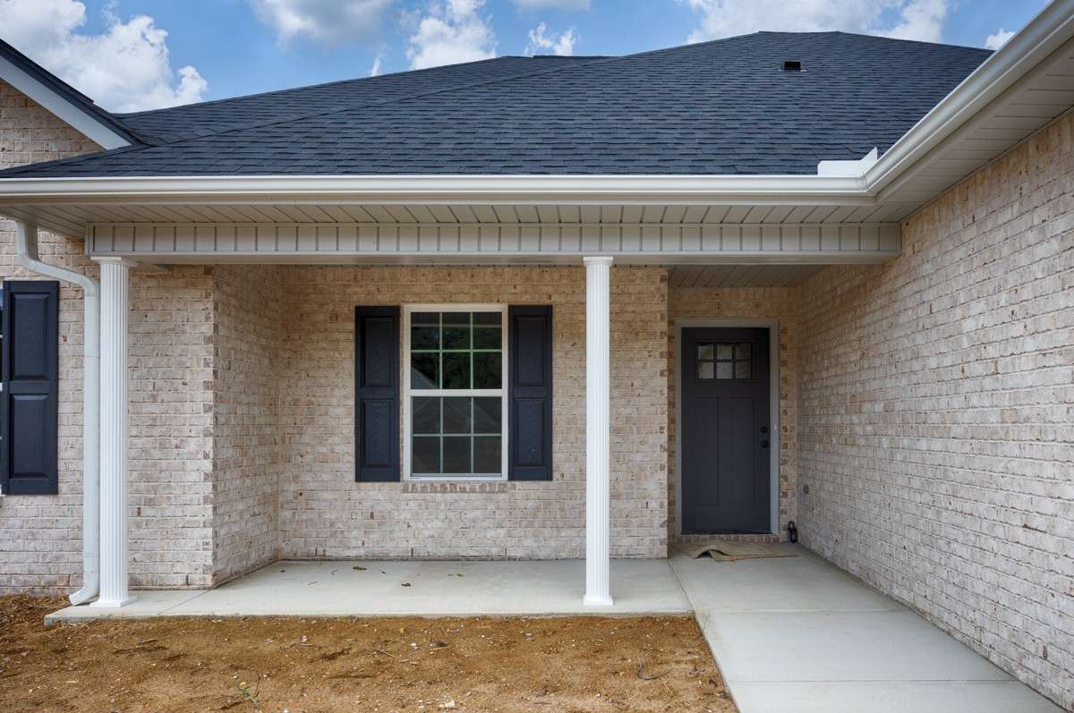 Full brick, two-car attached garage, concrete driveway and sidewalk, covered front porch with home entry