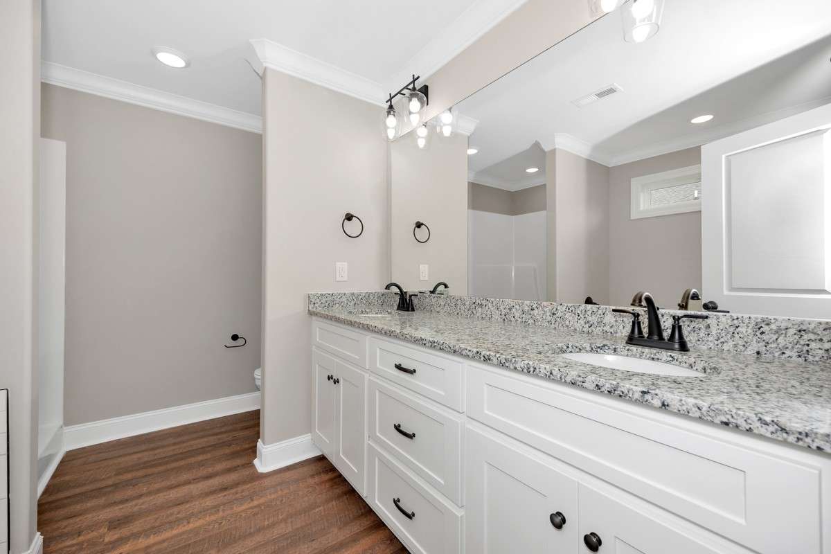 Primary Bath- LVP flooring, crown molding, separate tub & shower, double vanities