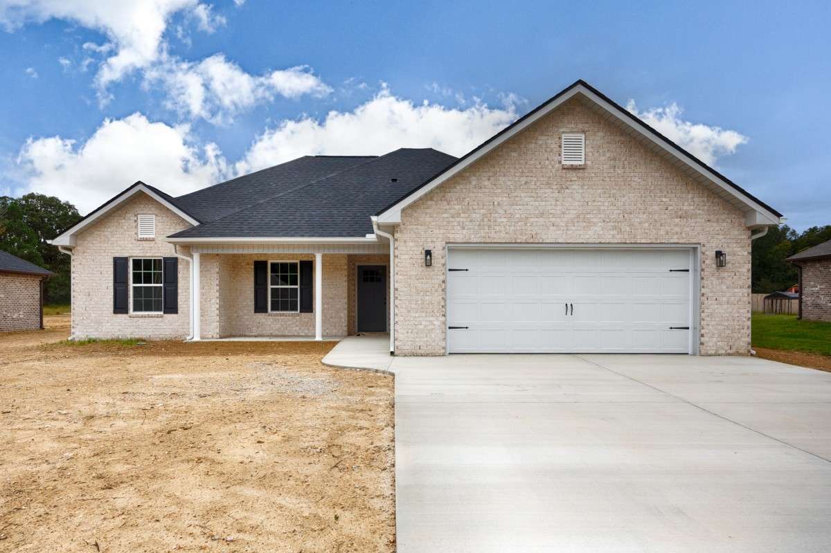 Full brick, two-car attached garage, concrete driveway and sidewalk, covered front porch with home entry