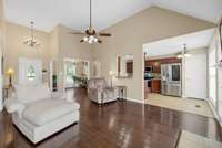 Family Room looking back to the foyer. Vaulted ceiling, hardwood flooring and open to the eat-in kitchen