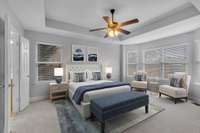 The main level primary bedroom is a spacious and relaxing retreat with bay windows and decorative trey ceiling.