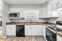 Tons of cabinet and counter space with a window overlooking the fenced backyard.
