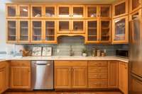 Glass-front cabinetry and beautiful tile backsplash