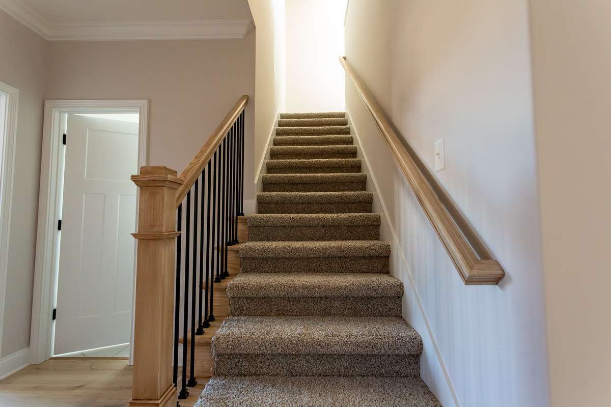 Stairway leading to upstairs where there is a bonus room, two bedrooms and a bathroom.