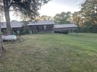 Looking at back of house, the far right is the carport large enough to cover an RV and boat