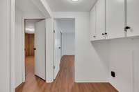 Hallway towards the back of the home with space for washer/dryer.