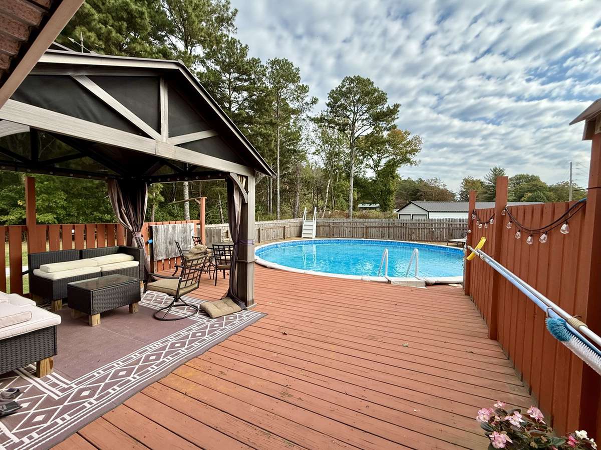 The back porch runs the length of the house and onto the deck and pool which is surrounded by privacy fencing.  The Gazebo and wicker furniture convey with the property.  So, you are all set to enjoy your summer swimming or lounging by the pool.