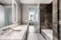 Stone shower, double vanities, back lit mirrors