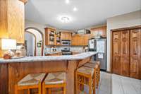 The kitchen has a raised bar giving ample seating space for the family or guest.