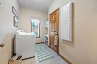 The laundry room is located in the  hallway close to the primary bedroom. It is complete with a built in ironing board