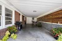 Covered patio with wood privacy accents, ideal for outdoor seating and entertaining