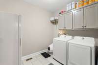 Nice large laundry room with cabinets for storage and room for a freezer.