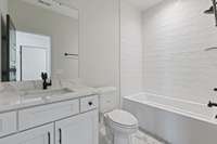 Guest bathroom with single vanity, modern light fixture, tile flooring & tiled combo tub & shower. 5511 Urbandale Ave Nashville, TN 37209