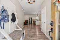 Entry foyer opens to a drop zone area and a half bath to the right.