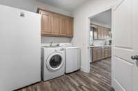 Convenient XL utility room located just off the garage with pantry storage and easy access to the kitchen.