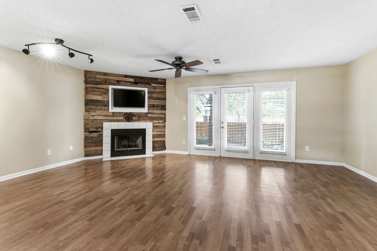Open concept living and dining which overlooks the patio and fenced backyard