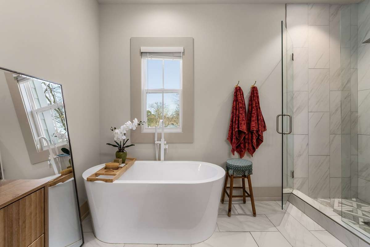 A freestanding soaking tub positioned beneath soft natural light—an inviting focal point that turns an everyday routine into a calming ritual.
