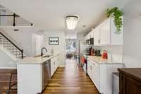 Open, functional updated kitchen with counter seating, stainless appliances, granite and pantry