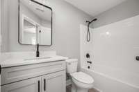 The hall bathroom features a tub/shower combo, vanity with soft close cabinets, quartz countertop and black hardware accents, luxury vinyl plank flooring - just a beautiful combination.
