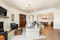 This cozy living area connects to the formal dining room. This open floor plan, filled with natural light is perfect for gathering, entertaining, and everyday living.