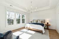 The primary bedroom is an inviting retreat, with a vaulted ceiling that adds to the spacious feel. Large windows let in the perfect morning light beaming from the Eastern sunrise.