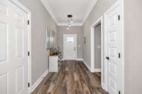 Foyer- LVP flooring, crown molding, recessed lighting