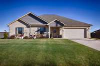 Front of house - Full brick, concrete driveway, covered front porch, gutters, classic landscaping, 2-car garage with single rollup door front facing