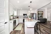 Kitchen- LVP flooring, kitchen island, tile backsplash, recessed lighting, crown molding, pantry, stainless steel appliances- refrigerator, microwave, stove/oven, dishwasher