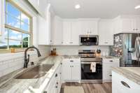 Kitchen- LVP flooring, kitchen island, tile backsplash, recessed lighting, crown molding, pantry, stainless steel appliances- refrigerator, microwave, stove/oven, dishwasher