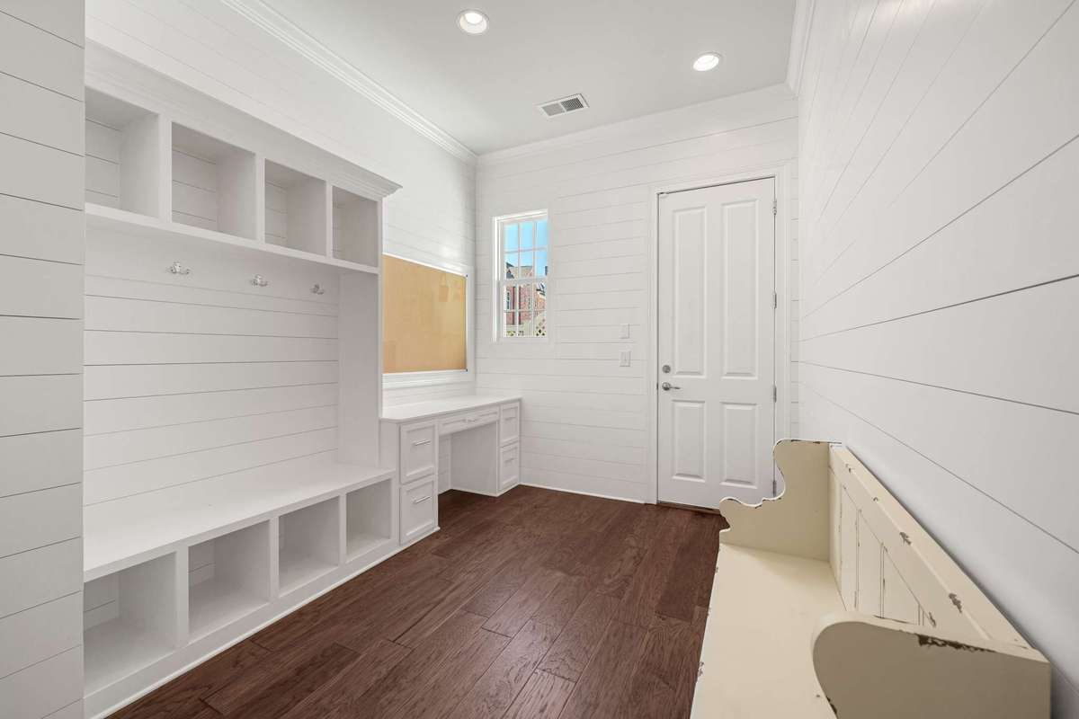 back entry from the garage (no steps) with ship-lap trim mud room cubbies, desk, and separate linen closet.   Picture window provides natural light