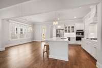 The kitchen offers double ovens, and a gas grill cooktop.