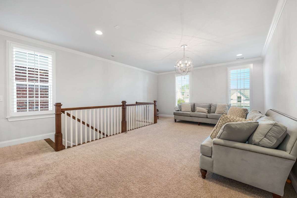 upstairs bonus room also has plantation shutters, multiple windows, and overhead recessed lighting.